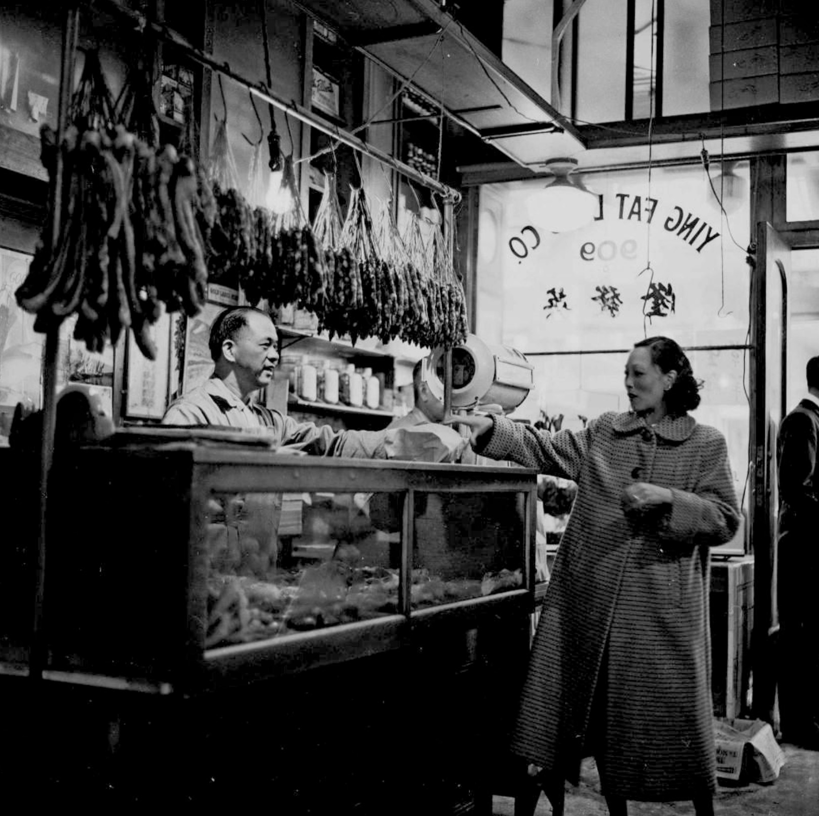 A lady shopping at Ying Fat Lung Co., a Chinese butcher shop in San Francisco, in 1955
